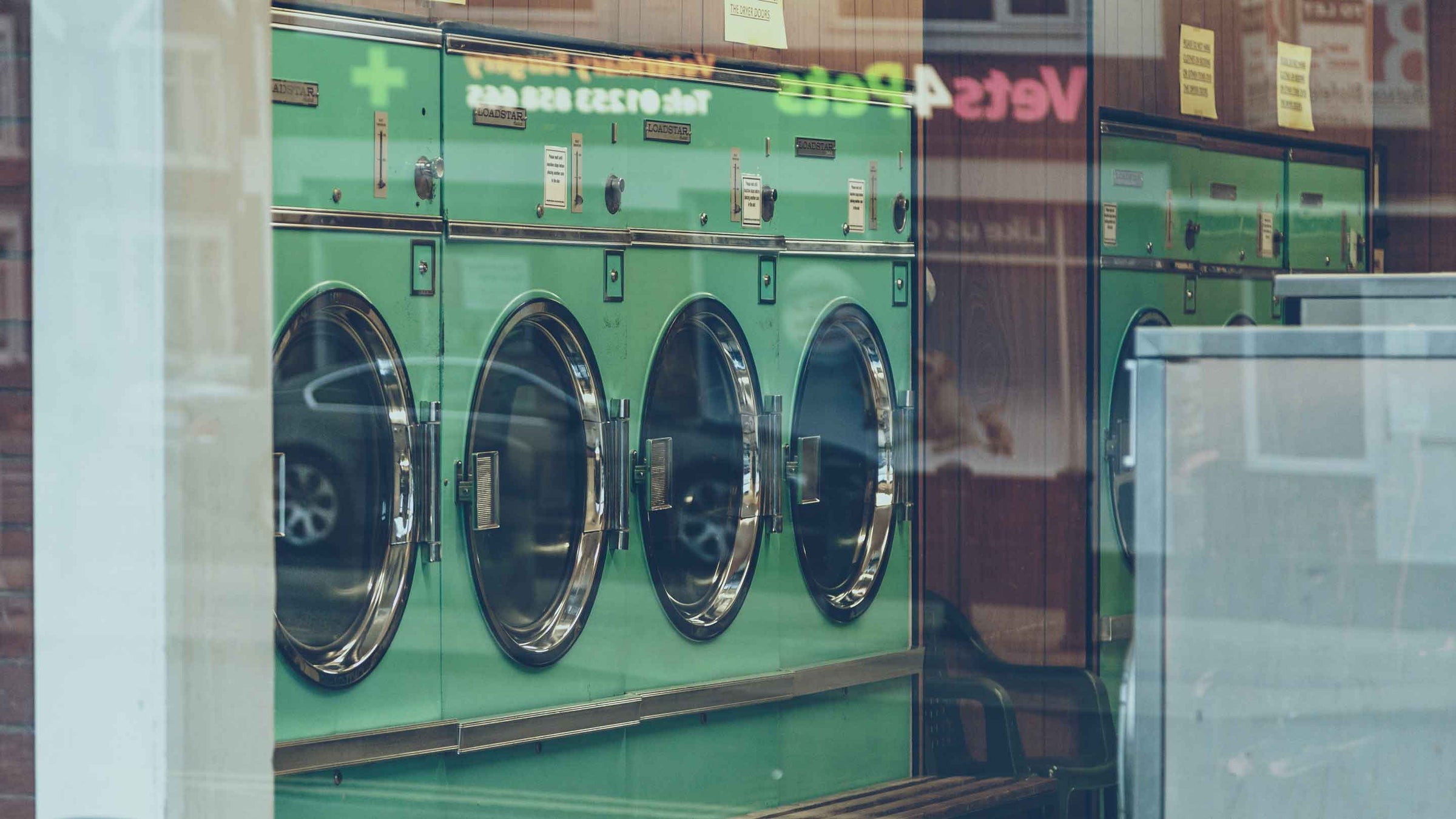 Washing machines in launderette window for garment care