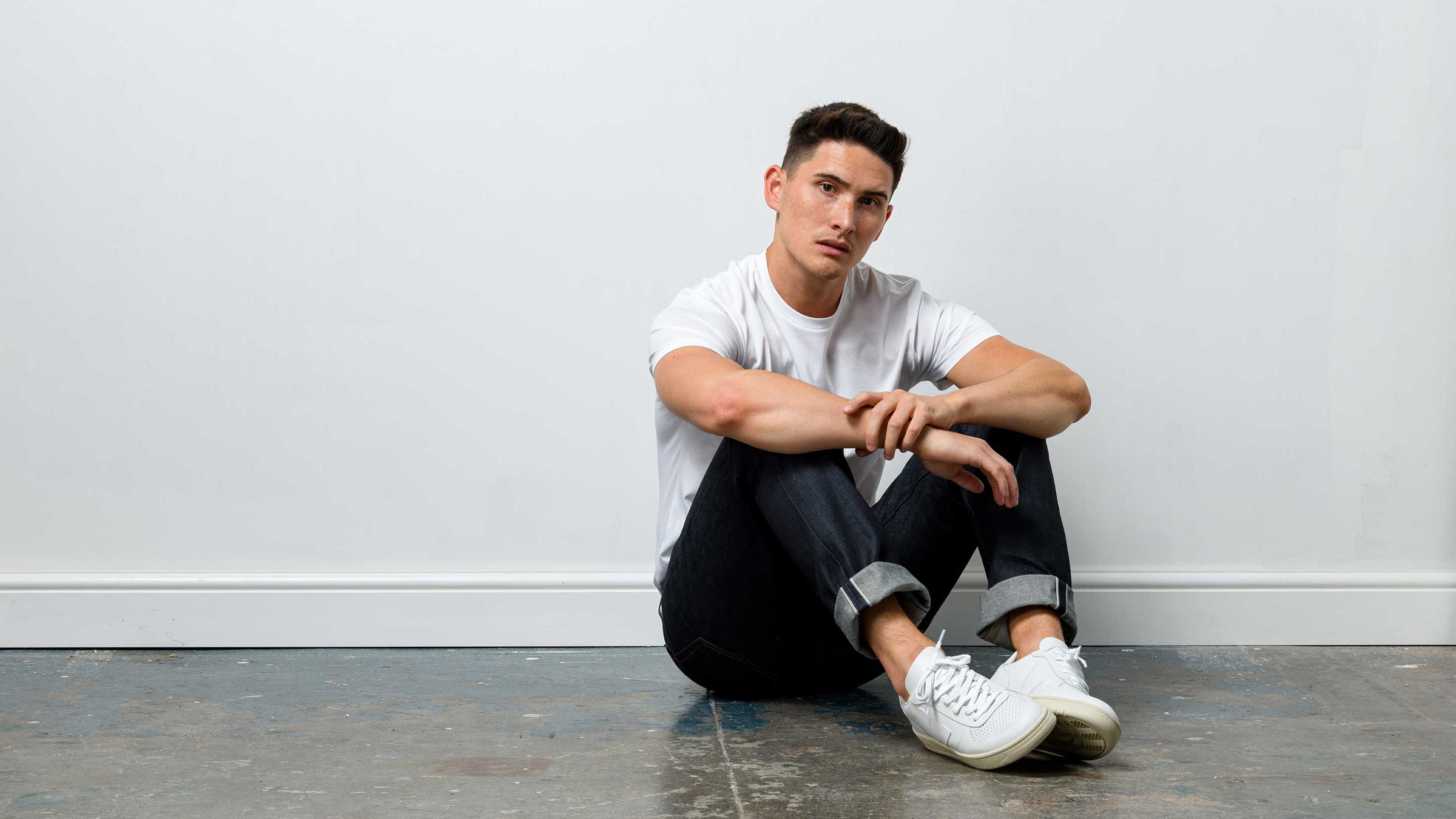 Model wearing white t-shirt denim jeans and veja sneakers